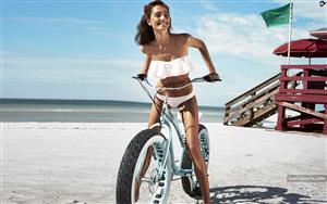 Josephine Le Tutour poses perfectly with a bicycle in strapless white bikini